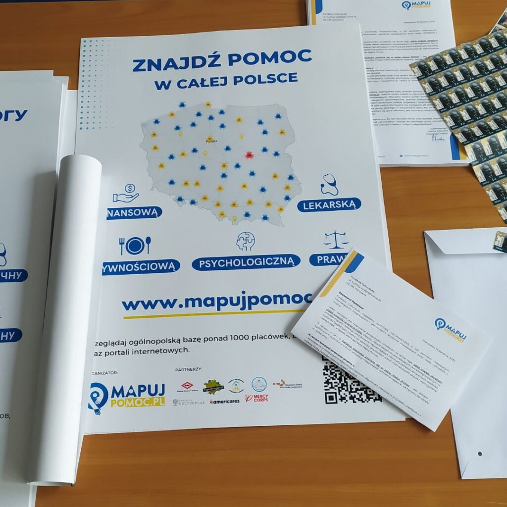 plakaty kampanii Mapuj Pomoc i inne materiały na biurku