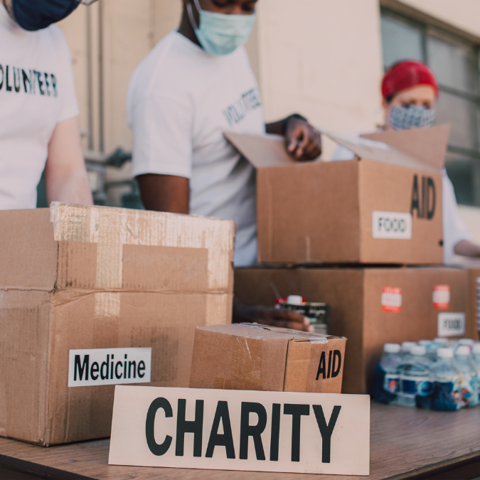 plakietka charity na stoliku i w tle pudełka