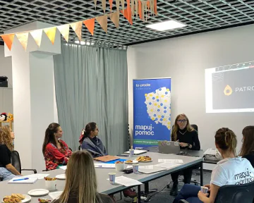 Spotkanie kobiet w sali konferencyjnej z bannerem 