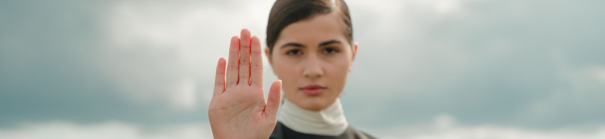 kobieta z podniesiono dłonią w geście STOP
