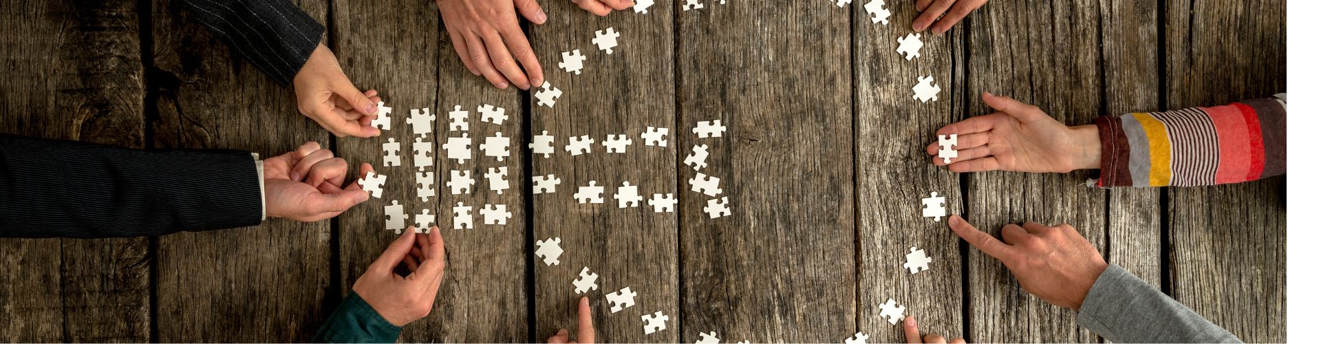 ludzie układający z puzzli żarówkę